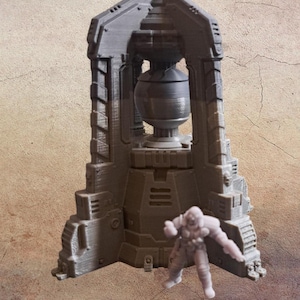 May include: A gray, 3D-printed miniature of a futuristic structure with a spherical object at its center. A small figurine of a person is standing in front of the structure. The structure has a detailed, architectural design.