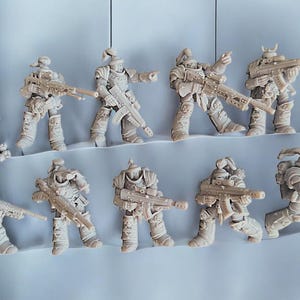 May include: Ten unpainted plastic miniature figures of soldiers holding rifles. The figures are posed in various action stances.