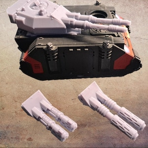 Può includere: Un modello di carro armato nero e rosso con una torretta grigio chiaro e due torrette di cannone grigio chiaro aggiuntive. Il carro armato presenta dettagli ed è ambientato su uno sfondo neutro.