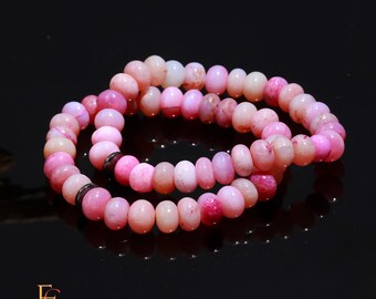 May include: Two pink and white gemstone bracelets with a silver accent. The bracelets are made of round beads and are stacked on top of each other.