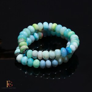 May include: A double-strand bracelet made of light blue, green, and white gemstone beads. The beads are round and have a smooth, polished finish.