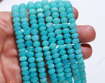 May include: A strand of turquoise blue gemstone beads. The beads are round and smooth, and they are strung on a clear thread. The beads are approximately 6mm in diameter.