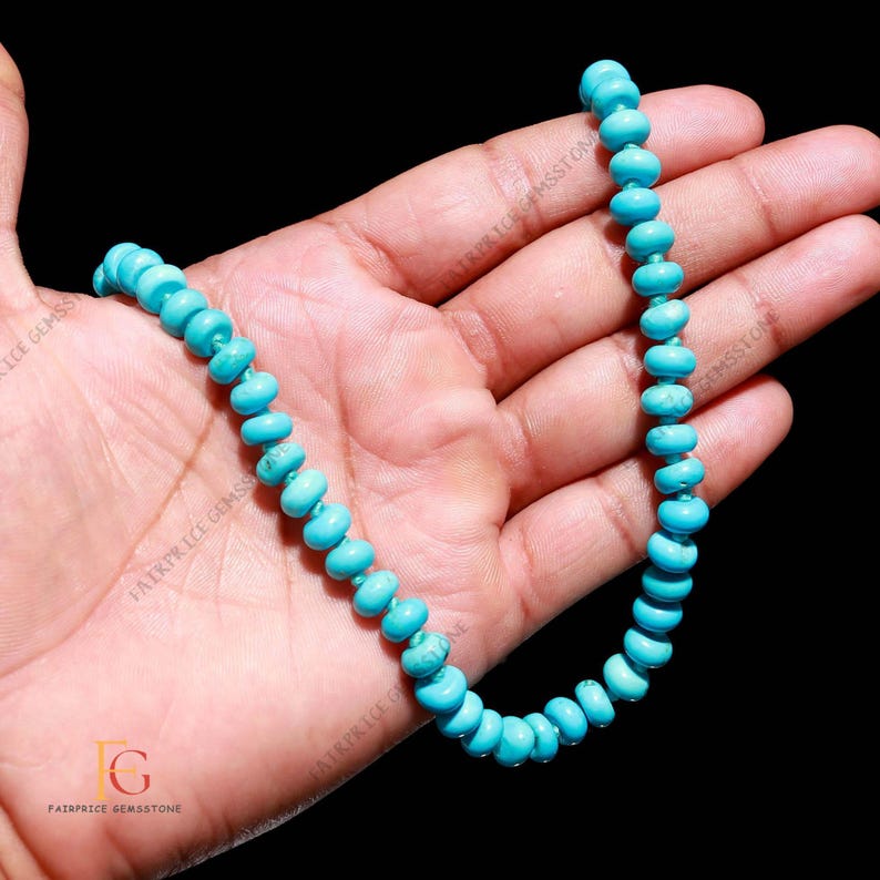 May include: A turquoise gemstone necklace with rounded beads. The beads are a bright, solid blue-green color. The necklace is displayed against a dark background.