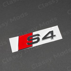 Op de afbeelding: Een chroom S4-embleem met een rode en witte achtergrond. Het embleem is een populair auto-onderdeel voor Audi-voertuigen.
