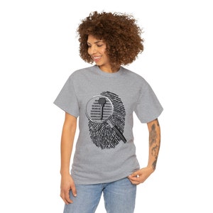 May include: A gray t-shirt with a fingerprint design and a magnifying glass over it. The magnifying glass shows binary code.