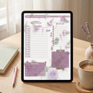 Puede incluir: Un planificador diario digital en una tableta, con un horario de 6:00 a 22:00, una lista de tareas y espacio para notas. El planificador tiene un diseño floral con acentos morados. Un bolígrafo, un libro y una taza de café están sobre la mesa de madera.