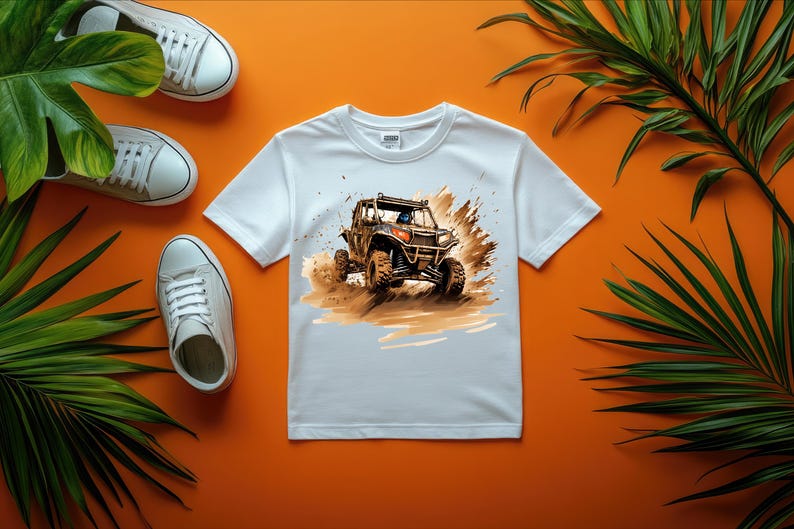 May include: White t-shirt with a graphic of a brown and black off-road vehicle driving through mud.