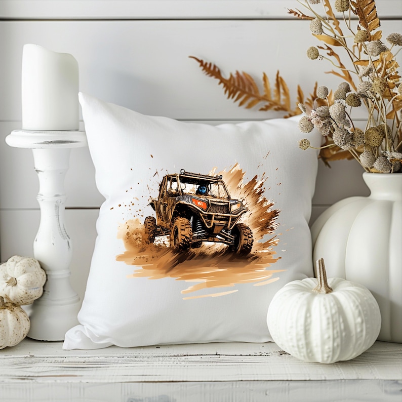 May include: White throw pillow with a graphic of a brown and black off-road vehicle driving through mud.