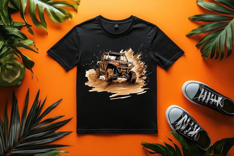 May include: Black t-shirt with a graphic print of a brown off-road vehicle driving through mud. The vehicle has a black roll cage and a black and orange color scheme.