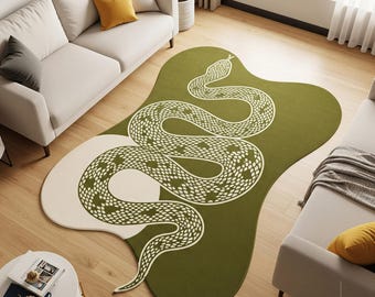 Puede incluir: Una alfombra verde y blanquecina con un diseño de serpiente. La alfombra tiene una forma orgánica con un fondo verde y un patrón de serpiente blanca. El texto "S.S. RUG CREATION" está en la parte inferior.