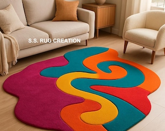 May include: A colorful, abstract area rug with a unique, flowing design. The rug features a mix of vibrant colors, including magenta, teal, orange, yellow, and red. The text "S.S. RUG CREATION" is visible on the rug. This rug is a statement piece for any living space.