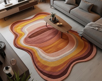 May include: A colorful, abstract area rug with a wavy, organic shape. The rug features bands of warm colors, including shades of brown, orange, yellow, and pink. The text "S.S. RUG CREATION" is visible in the bottom right corner. The rug is placed in a living room setting.