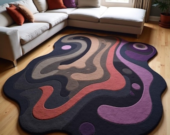 May include: Abstract area rug with a unique, organic shape. The rug features a layered design with shades of black, gray, brown, red, and purple. The text "S.S. RUG CREATION" is visible at the bottom of the rug.