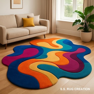 May include: A multi-coloured, abstract rug with a distinctive, flowing design. The rug features vibrant shades of blue, orange, yellow, and purple. The rug is a statement piece for any living space. The text "S.S. RUG CREATION" is visible in the bottom right corner.