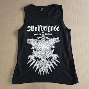 May include: Black tank top with a white graphic of a skull with wolf heads on either side. The graphic includes the text "Wolfbrigade" and "Barren Dreams".
