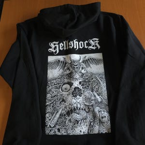 May include: Black hooded sweatshirt with the word "Hellshock" in white gothic lettering above a detailed black and white illustration of a demonic figure with wings, horns, and a skull.