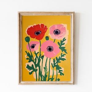 May include: A framed print featuring a stylized illustration of pink and red poppies with green stems on a yellow background.