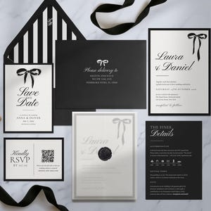 May include: Elegant black and white wedding stationery set. Includes invitations, RSVP cards, and envelopes with bow accents. The "Save the Date" card and invitation feature the names "Laura & Daniel". A black ribbon and spool add a decorative touch.