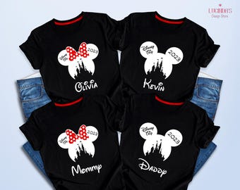 May include: Four black t-shirts with white text and graphics. The shirts feature a Mickey Mouse ear design with a castle inside. The text on the shirts reads "Disney Trip 2023" and includes the names "Mommy", "Daddy", "Olivia", and "Kevin".