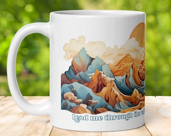 May include: White ceramic mug with a colorful mountain landscape design and the text "lead me through the valley" at the bottom.
