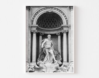 May include: Black and white photograph of a statue of a man standing in a fountain. The statue is surrounded by water and is set against a backdrop of a large archway.