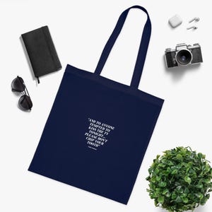 May include: A navy blue tote bag with white text that reads "AND TO ANYONE TEMPTED TO KISS THE TV TONIGHT... PLEASE DON'T CHIP YOUR TOOTH".