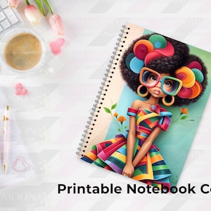 Puede incluir: Cuaderno con espiral con una colorida ilustración de una mujer con gafas grandes y un vestido arcoíris. La portada del cuaderno tiene el texto "Printable Notebook Covers". La imagen está sobre un escritorio blanco con un teclado, bolígrafos y flores.