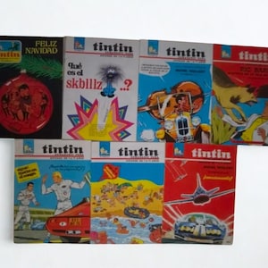 Może przedstawiać: Kolekcja komiksów Tintin w stylu vintage. Okładki zawierają kolorowe ilustracje i tekst w wielu językach. Niektóre okładki przedstawiają sceny akcji, a inne mają świąteczny motyw.