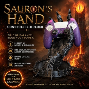 May include: A black controller holder in the shape of Sauron's hand, holding a purple and white PlayStation controller. The base is black with spikes. Text on the holder reads "SAURON'S HAND CONTROLLER HOLDER". Inspired by Sauron & Barad-Dûr.