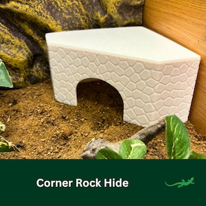 May include: White corner rock hide for reptiles, with a textured stone design and a large opening.  Corner Rock Hide.