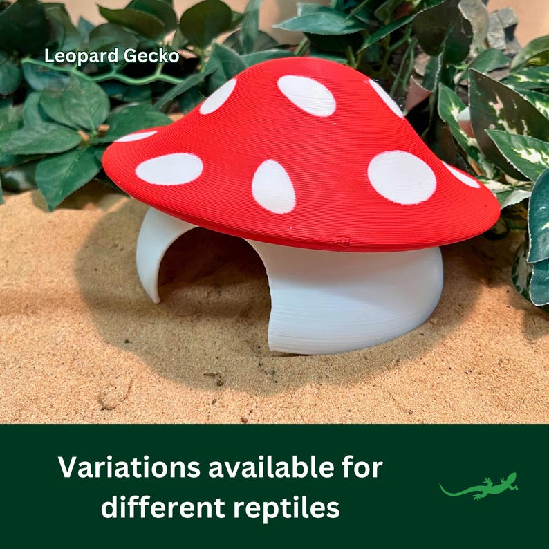Puede incluir: Escondite para reptiles en forma de hongo rojo y blanco con el texto "Leopard Gecko" en la parte superior. Variaciones disponibles para diferentes reptiles.