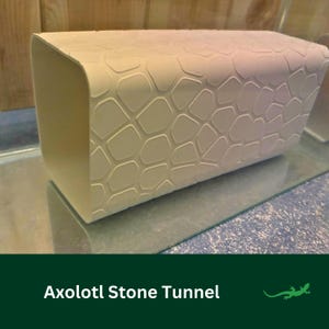 May include: A white plastic tunnel with a stone-like texture, designed for axolotls. The tunnel is shaped like a half-cylinder and has a smooth, rounded opening.