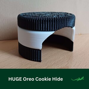 May include: A black and white 3D printed Oreo cookie hide for small reptiles. The hide is shaped like a half-eaten Oreo cookie.