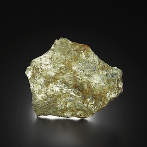 May include: A rough, irregularly shaped mineral specimen with a shimmering, golden-yellow hue. The surface has a crystalline structure, reflecting light and creating a textured appearance. The rock sits against a dark background.