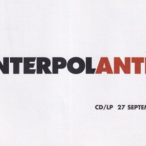 May include: A white background with the text "INTERPOLANTICS" in black and red block letters. Below the title is the text "CD/LP 27 SEPTEMBER 2004". The design is simple and bold, with a retro aesthetic.