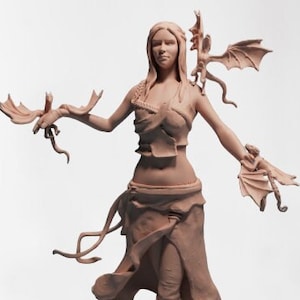 May include: A figurine of a woman with long flowing hair, wearing a leather-like outfit and holding two small dragons in her hands. The dragons are in flight and have wings outstretched.