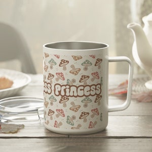 Può includere: Tazza da viaggio in acciaio inox bianco con un design a fungo e "Principessa del Bosco".