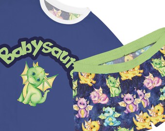 Könnte beinhalten: Blau-grüner Schlafanzug mit einem Baby-Dinosaurier-Motiv und dem Text "Baby Saur" auf dem Oberteil. Die Hose hat einen Druck mit bunten Baby-Dinosauriern auf dunkelblauem Hintergrund.