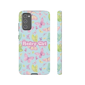 Può includere: Una custodia per telefono blu chiaro con un motivo di farfalle colorate e il testo "Baby Girl" in rosa.