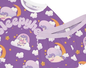 Könnte beinhalten: Lilafarbener Pyjama-Set mit einem Einhorn-, Mond- und Wolkenmuster. Das Oberteil trägt den Text "Sleepyheads".