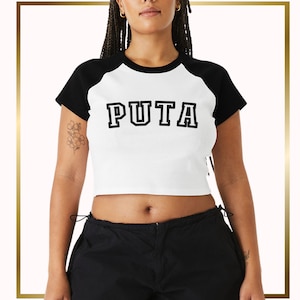 May include: A white cropped t-shirt with black sleeves and a black "PUTA" graphic printed on the front.