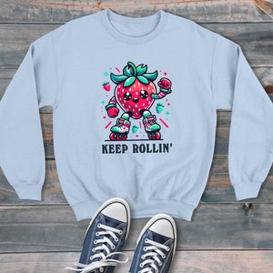 Fresa en patines sigue rodando sudadera unisex estilo dibujos animados, suéter gráfico retro, estilo moderno y divertido