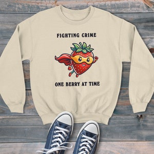Sudadera unisex estilo dibujos animados de superhéroe de fresa que lucha contra el crimen, suéter gráfico retro, estilo moderno y divertido