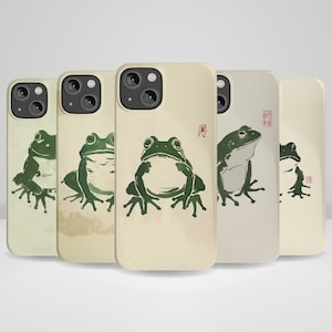 May include: Five different phone cases with a green frog design and a Japanese character on the back. The cases are all beige with a subtle watercolor effect.