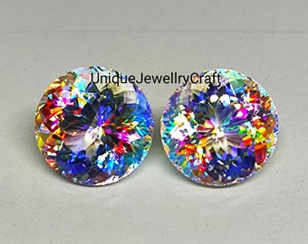 May include: Two round, iridescent gemstones with a rainbow of colors, including red, orange, yellow, green, blue, and purple. The gemstones are set against a white background.