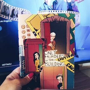 May include: A red, yellow, and blue illustrated notebook with the text "Only Murders in the Building" and "Caution" on the cover.