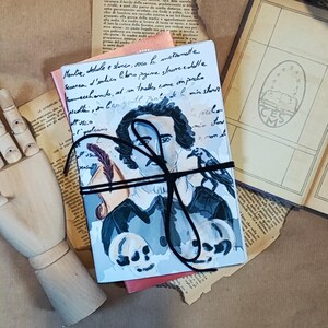 Può includere: Un diario blu e bianco con un nastro nero legato intorno. La copertina presenta un disegno di un uomo con un corvo nero sulla spalla. Il diario ha il testo "Mentice, delade e stanca, voco la metanalle Secerca d'enlies libro prime strove edelle Sammecchando, ad un tralls come am precho sedlin, in bere gentil pralia de I misstant Equoleums" scritto su di esso.