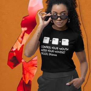 May include: Black t-shirt with white text that reads "Control your mouth, alter your mindset, delete drama". The text is styled to look like computer keys with the words "Ctrl", "Alt", and "Del" above the text.