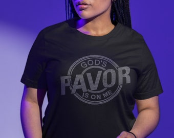 May include: A black t-shirt with a white rhinestone design that reads "God's Favor Is On Me".
