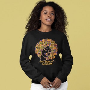 May include: Black sweatshirt with a colorful graphic of a woman's face with an afro and the text "My Black is Beautiful".